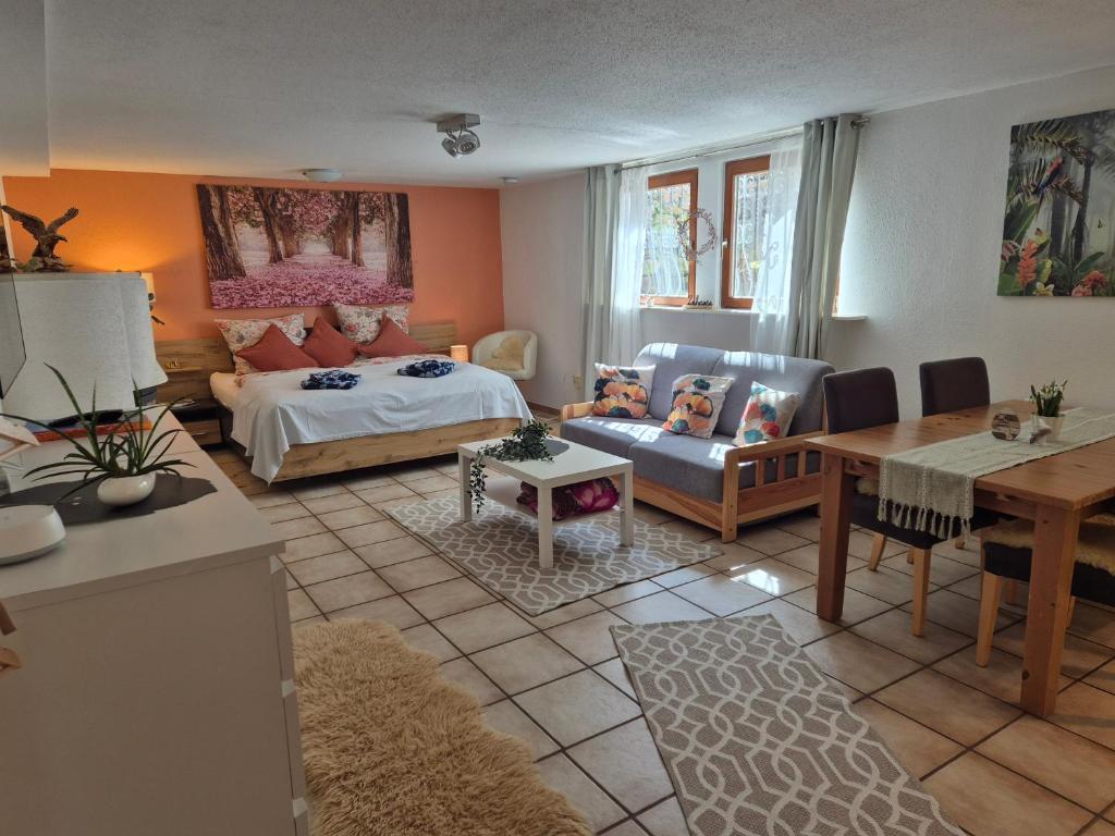 a living room with a bed and a table at Ferienwohnung Waldnest in Elmstein
