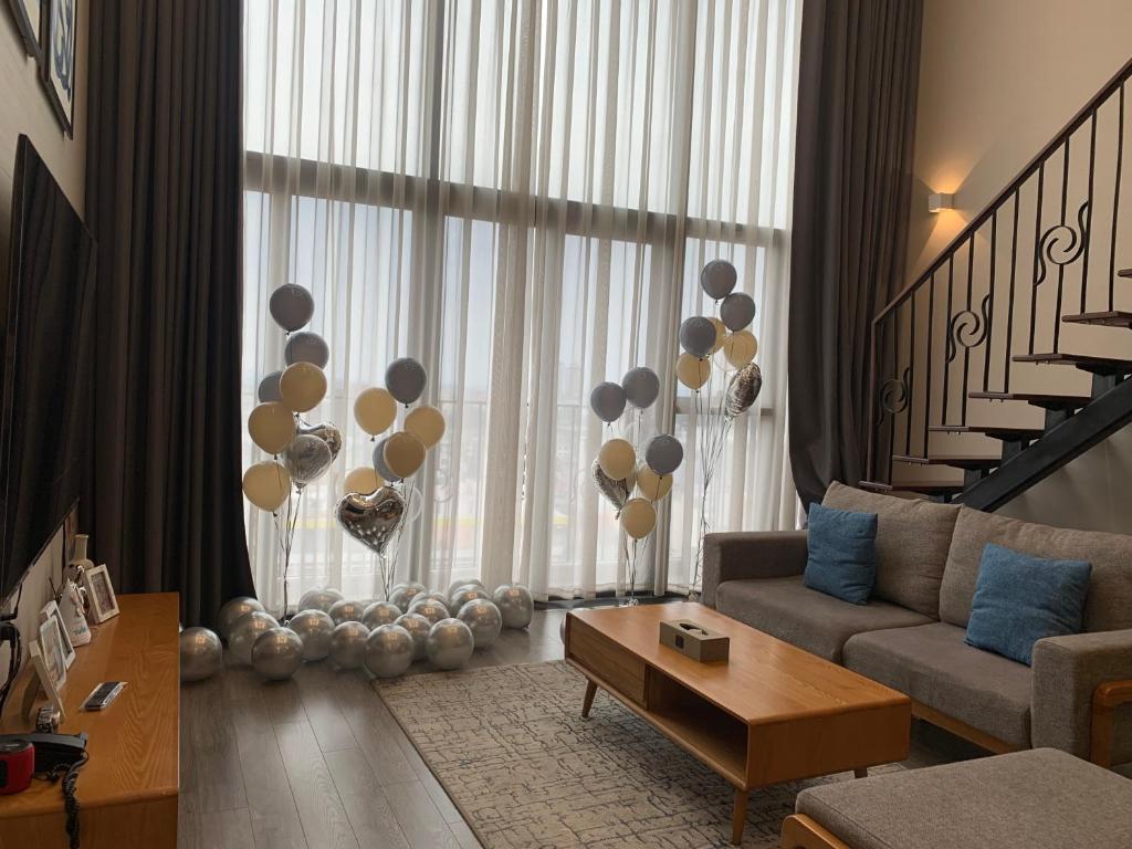 a living room with a couch and balloons in front of a window at Westlake view Duplex Studio in Hanoi
