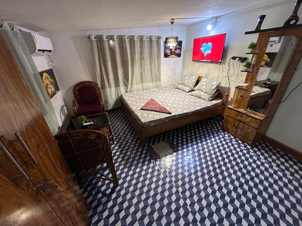 a small bedroom with a bed and a chair at Luna leaf Homestay in Guwahati