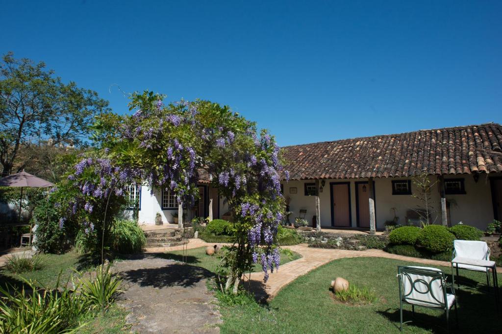 a house with a flowering tree in the yard at Pousada da Bia in Tiradentes