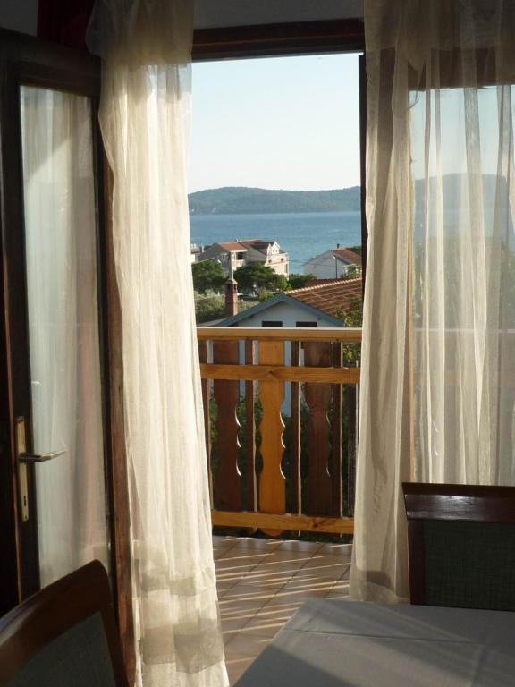 a bedroom with a view of the ocean from a balcony at Jelena i Agi apartman Bibinje in Bibinje