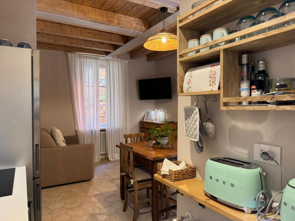 a kitchen and dining room with a table and a refrigerator at Casa Melox in Lezzeno