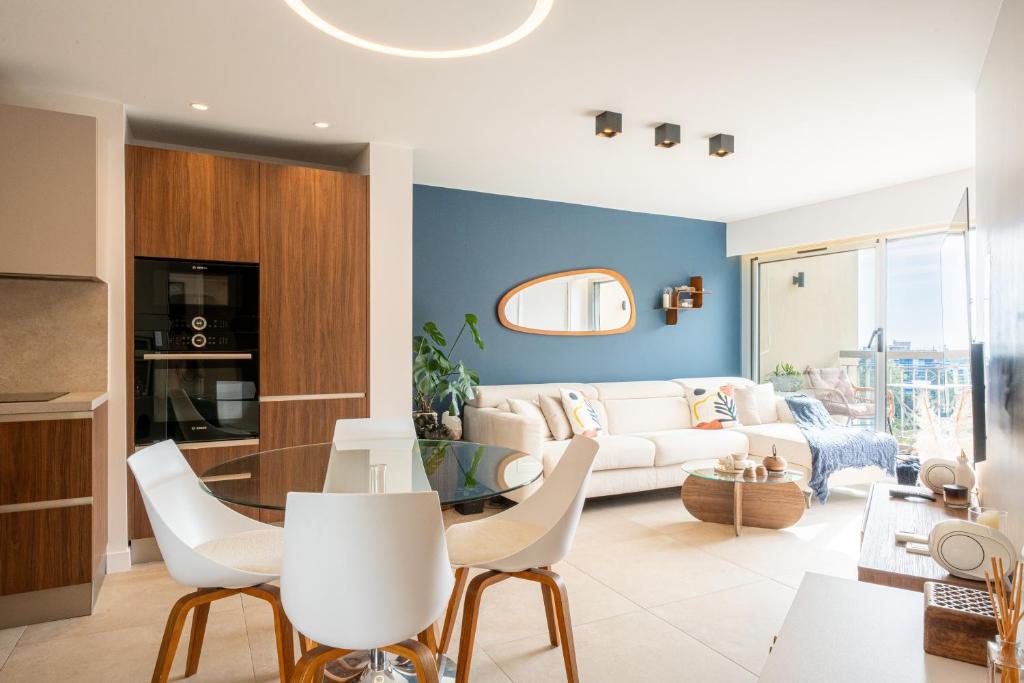 a living room with a white couch and chairs at Appartement luxe vue mer et collines avec piscine in Mandelieu-La Napoule