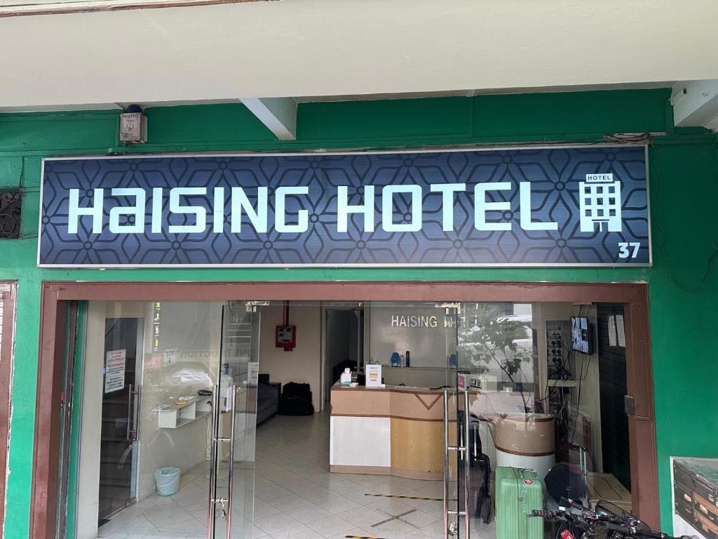 ein hängendes Hotelschild an der Vorderseite eines Gebäudes in der Unterkunft Haising Hotel in Singapur