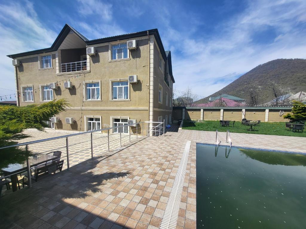 a building with a pool of water in front of it at Gabala Comfort Inn in Gabala