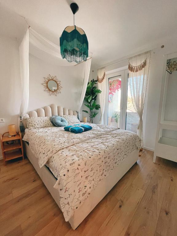 a bedroom with a large bed with a chandelier at Angel's Home in Dunajská Streda