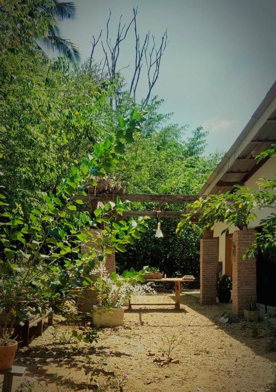 a garden with a bench and trees and a building at GARDEN House in Ban Phru Ching (1)