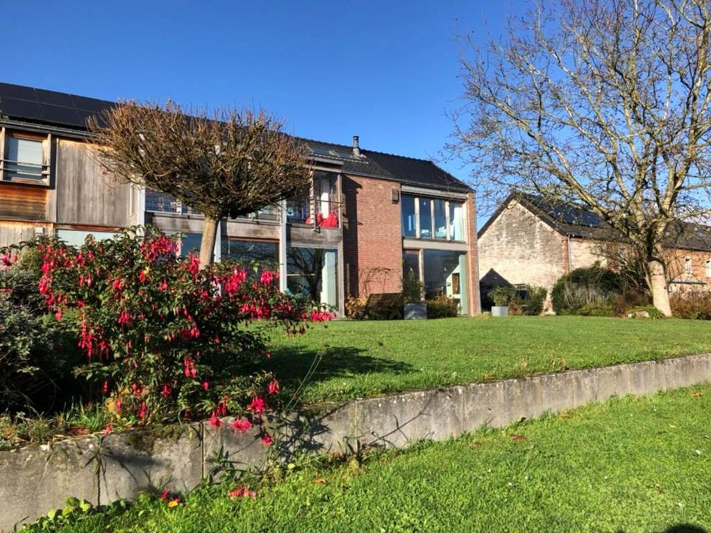 a large brick house with red flowers in the yard at Au Grand Babin - Namur in Namur