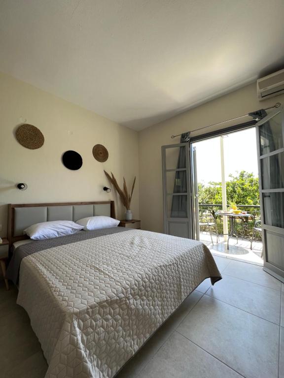 a bedroom with a bed and a sliding glass door at Ninemo Residences Skiathos in Achladies