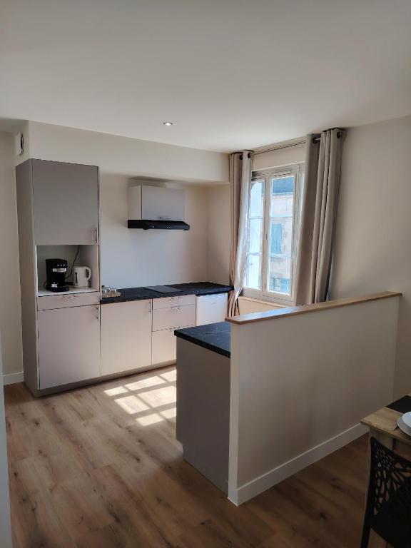 a kitchen with white cabinets and a counter top at Logement 2 cité de caractère in Mallièvre
