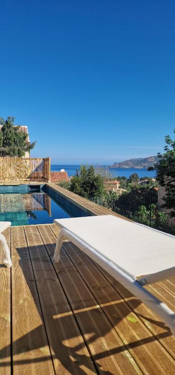 a white bed sitting on a wooden deck next to a swimming pool at Residence Mara Dea in Galeria
