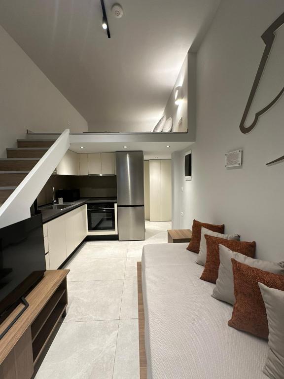 a living room with a white couch and a kitchen at Modern Lofts in Archangelos Rhodes with Parking - Equus - 3 Guests in Archangelos