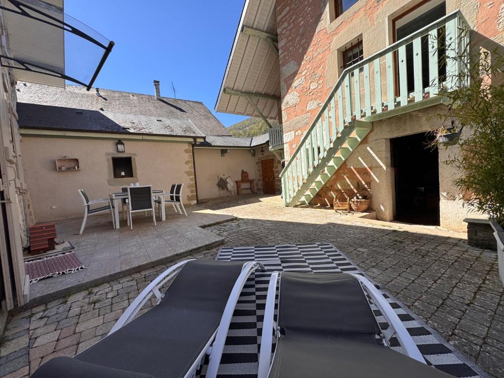 a patio with a table and chairs and a building at Maison de Saint Ours in Moye