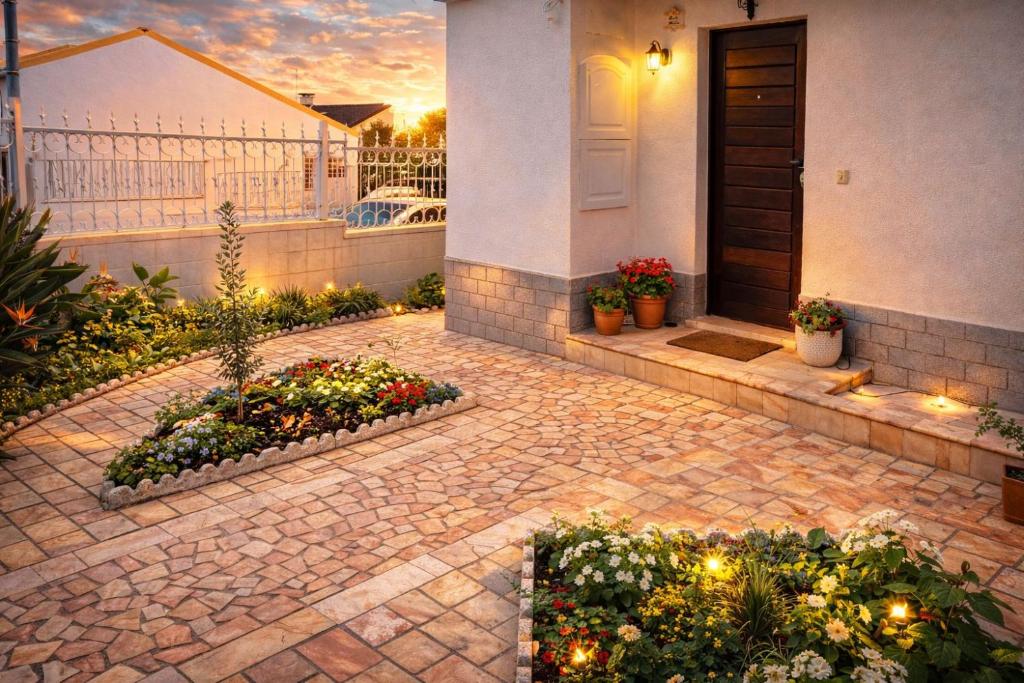 a house with a courtyard with flowers and a door at Cozy Room in Corroios Near Beach & Lisbon - Quarto Acolhedor em Corroios Perto da Praia e Lisboa in Corroios