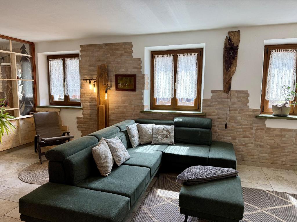 a living room with a green couch and a table at Appartamento Il Conte di Avoscano in Piaia