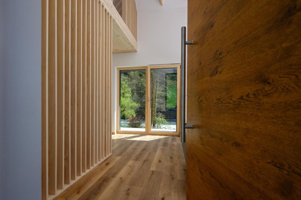 a hallway with a wooden door and a window at Cirus Riverfront Kolpa & Rafting in Kočevje