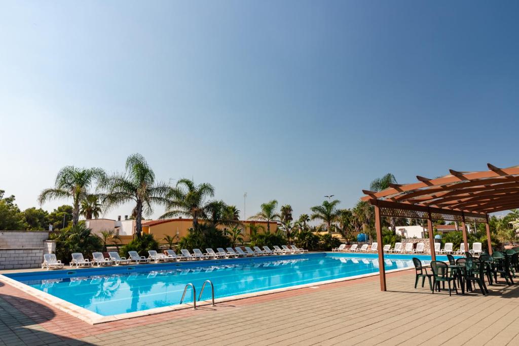 a large swimming pool with chairs and a table at Racar Hotel in Frigole