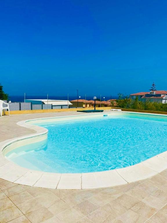 a large swimming pool with blue water at SHARED SWIMMING POOL, House relax Lu Bagnu in Castelsardo