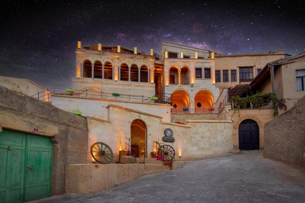 a large building with green doors at night at Dionysos Cave Cappadocia in Ürgüp