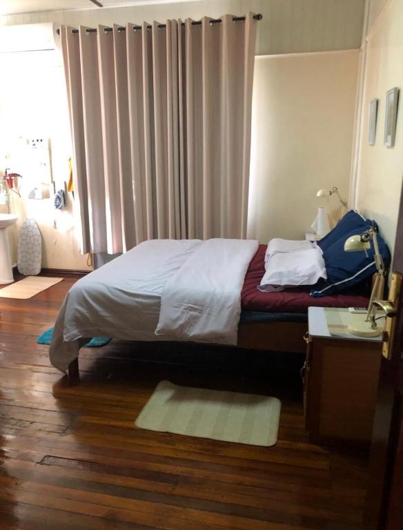 a bedroom with a bed and a desk and a window at staylikehome guesthouse in Nieuw Nickerie