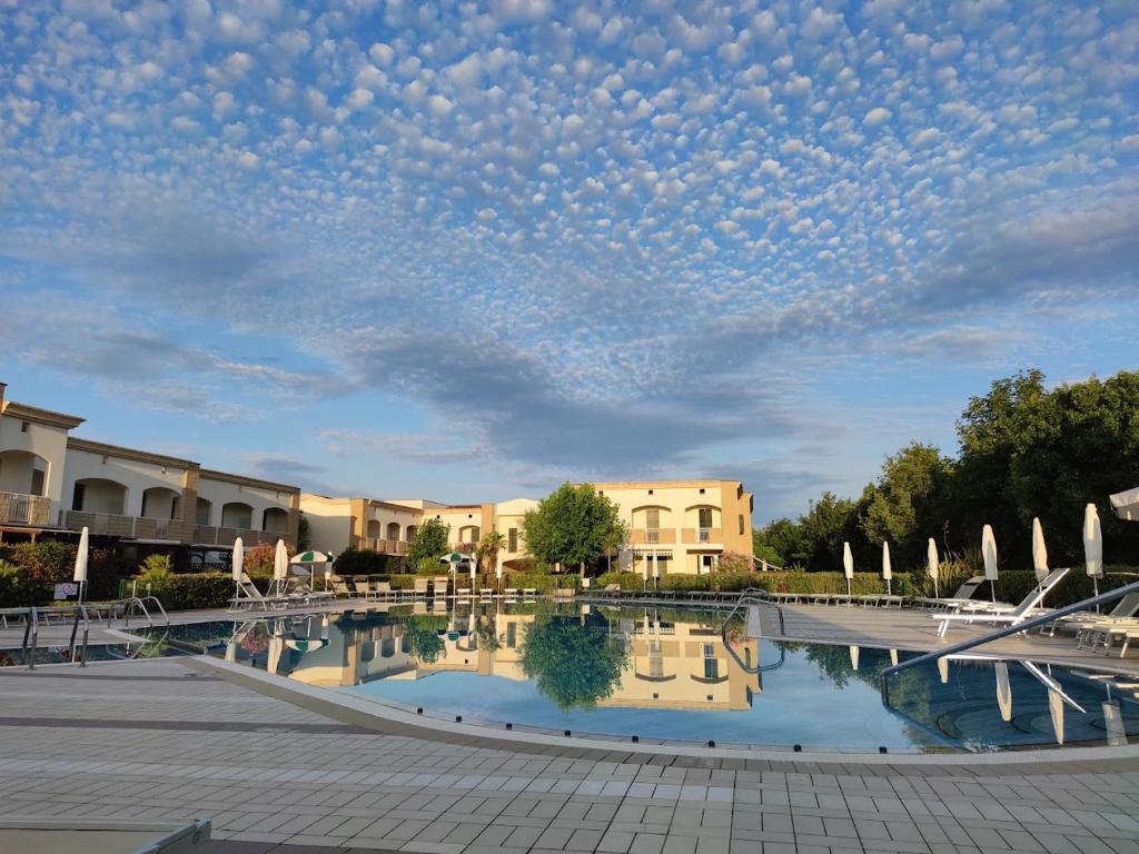 a view of a courtyard with a large pool at Mamì Altanea Village in Duna Verde