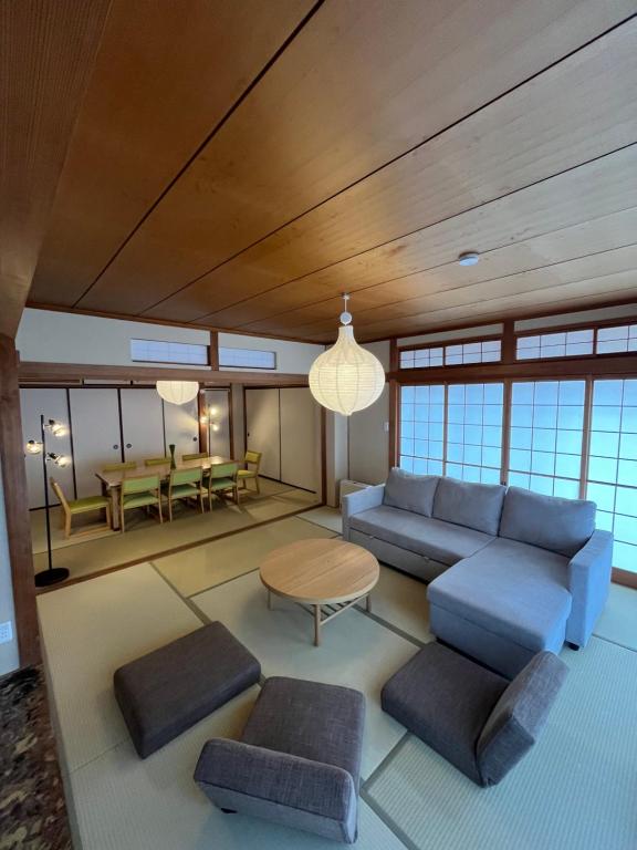 a living room with a blue couch and a table at 伊都伎-Itsuki- 宮島口の貸切一軒家 世界遺産宮島へ渡る港まで徒歩圏内 最大16名 in Hatsukaichi