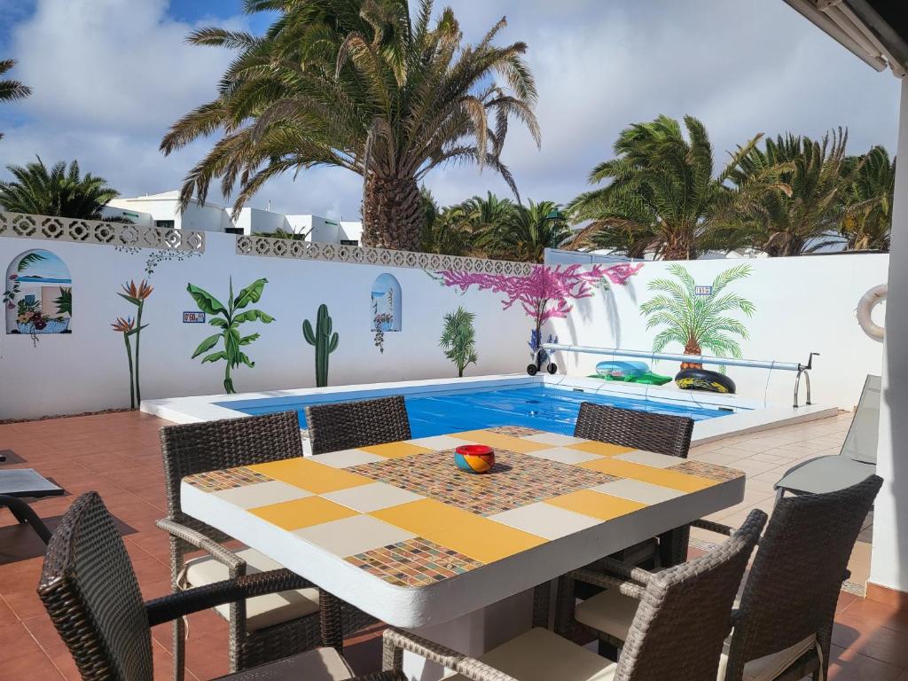 a patio with a table and chairs and a swimming pool at Villa Acoran in Costa Teguise