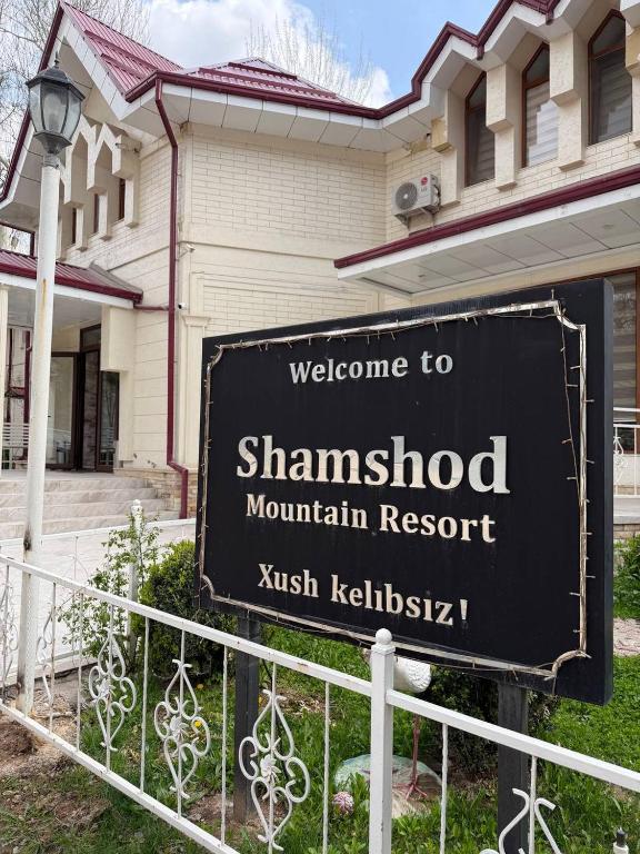 a sign for the shanghaihibited mountain resort in front of a house at Shamshod Mountain Resort in Yangiobod