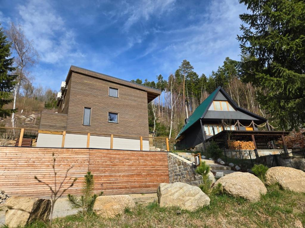 a wooden house with a fence in front of it at Hillside Cabin in Pomezí