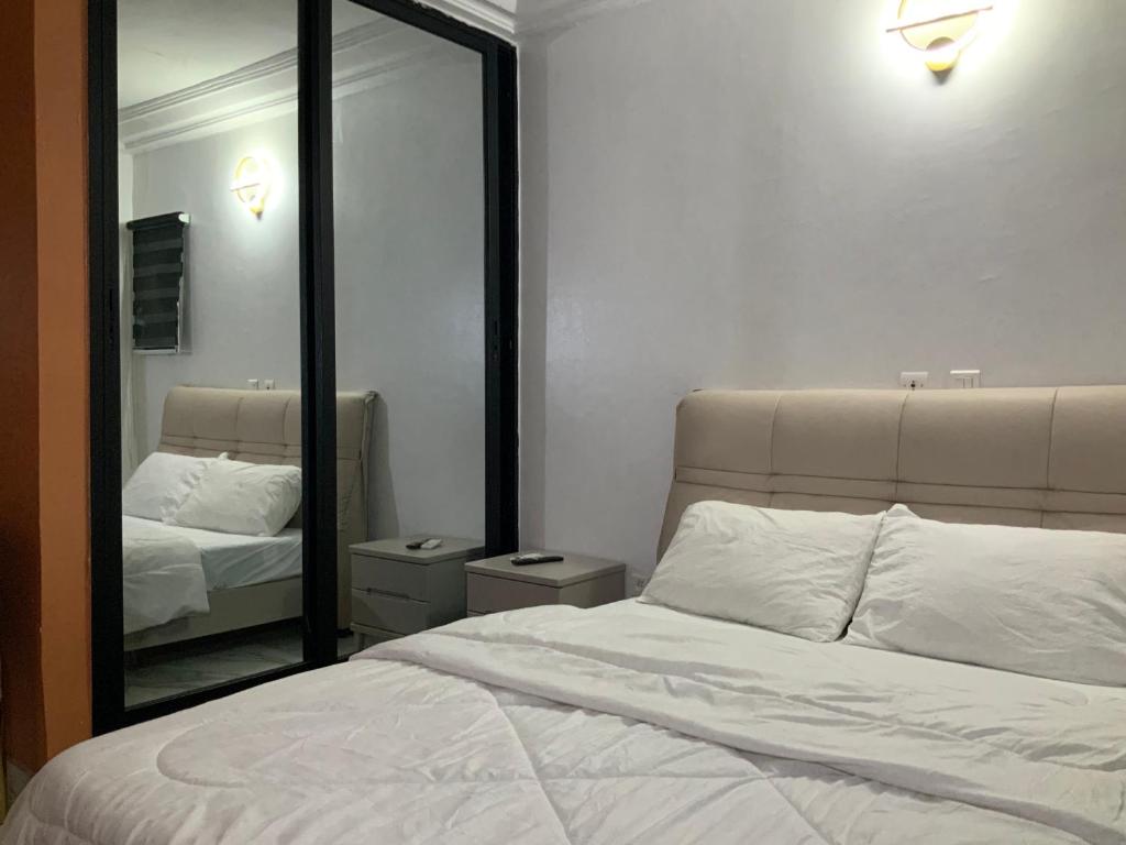 a bedroom with a bed and a large mirror at La MAISON SEONE SILVER in Abidjan