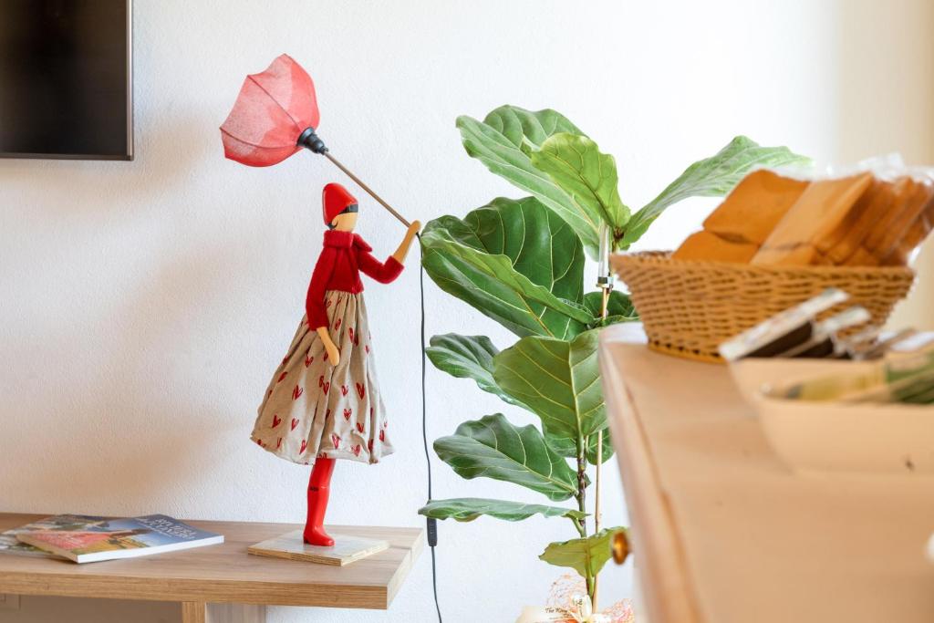 a figurine of a woman holding an umbrella on a table at Aghèl Luxury Room in Recanati