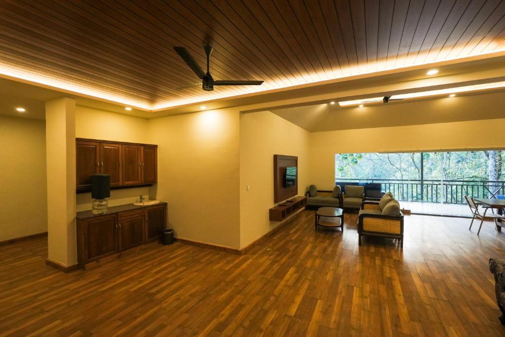 a large living room with a couch and a tv at Elixir Woods Luxury Resort And Spa, Munnar in Munnar