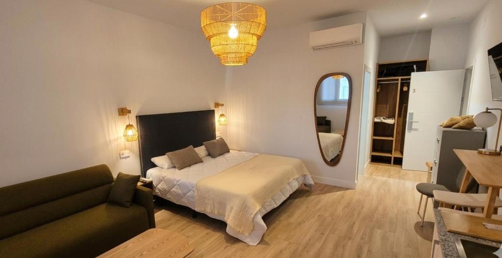 a bedroom with a bed and a couch and a mirror at Las Casitas del Canal Acueducto in Segovia