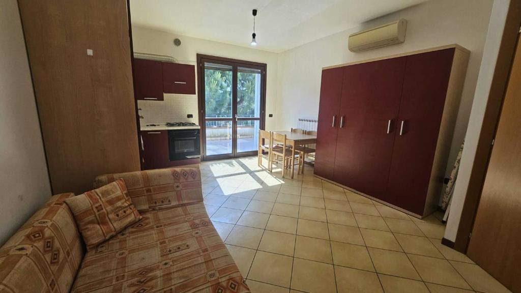 a living room with a couch and a kitchen at Functional and equipped apartment in Rosolina in Rosolina Mare