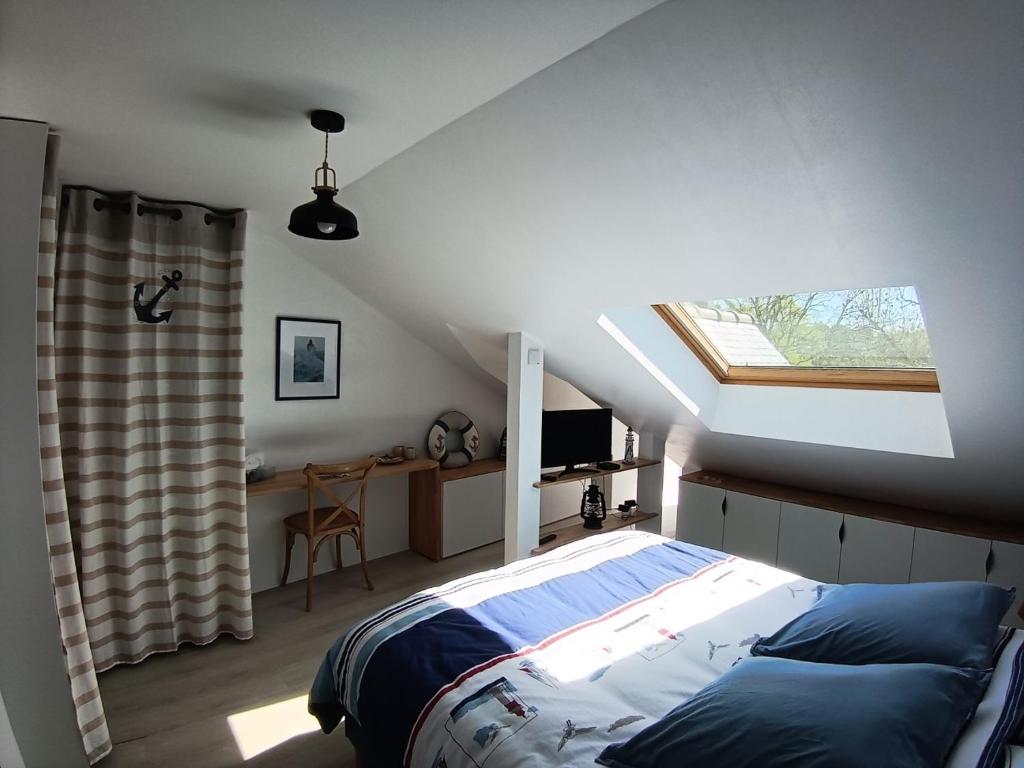 a bedroom with a bed and a window in a attic at la demeure des songes in Josselin