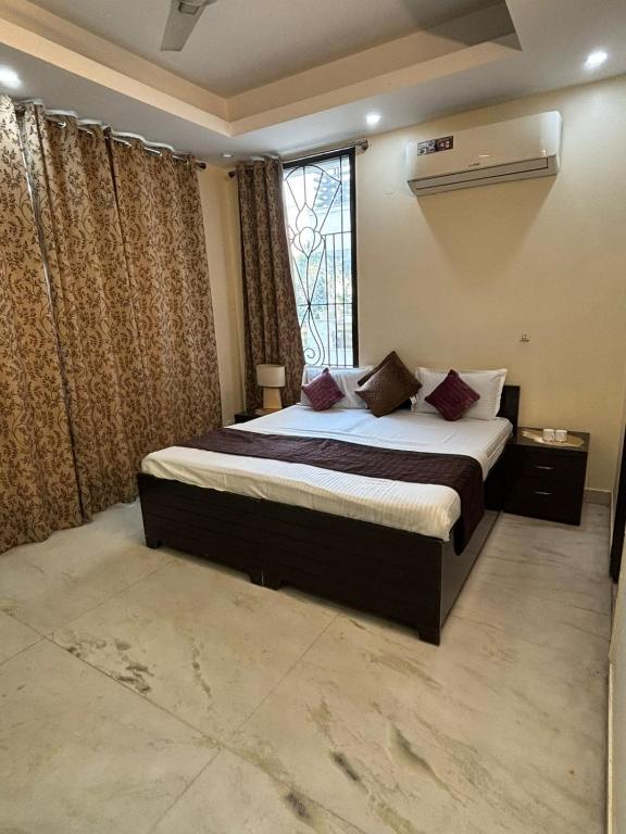 a bedroom with a large bed and a window at Sarla Residency in Noida