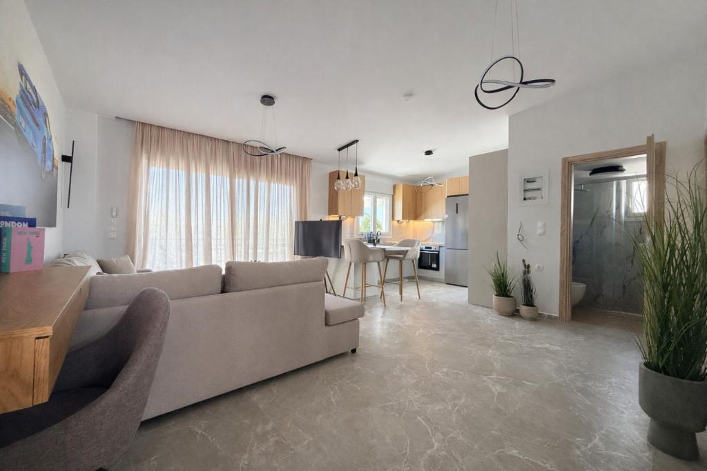 a living room with a couch and a dining room at Aura Residence Beachfront by Horizon Homes in Ofrínion