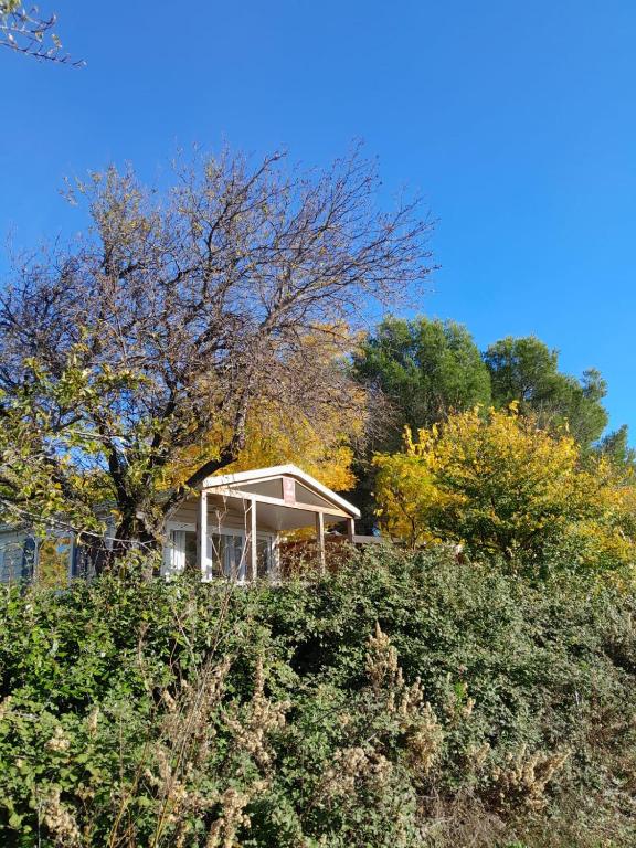 a house sitting on top of a hill with trees at Camping Fontisson in Châteauneuf-de-Gadagne