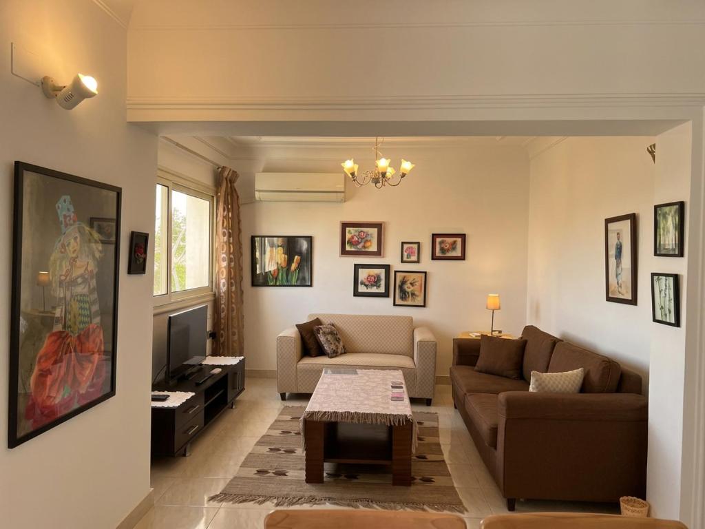 a living room with a couch and a table at Maison de Lama - Expat friendly, AirCon, Garden access in Cairo