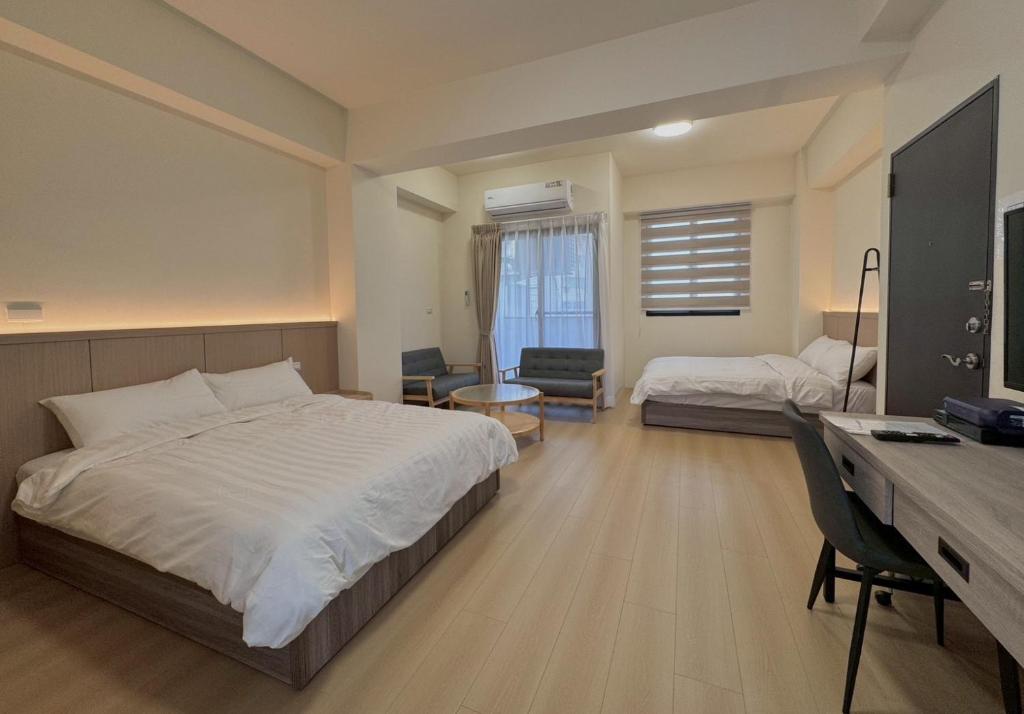 a bedroom with a bed and a desk with a computer at 星爍民宿 in Ch'ih-k'an-lou