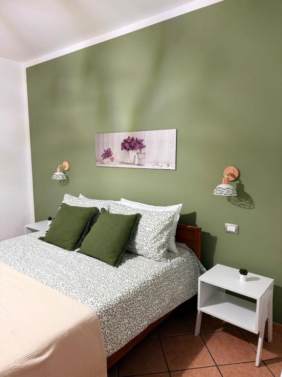 a bedroom with a bed and a green wall at Casa Rina in Piano Conte