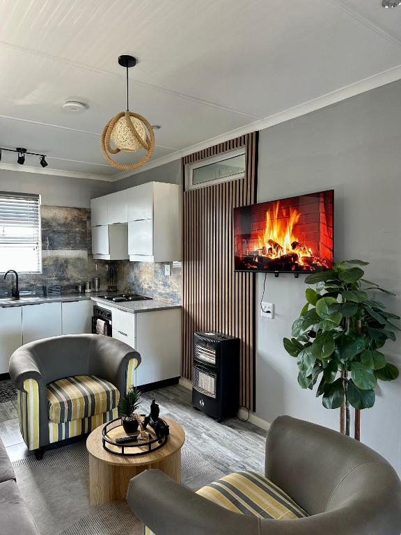 ein Wohnzimmer mit einem Kamin in der Wand in der Unterkunft Cingar Suites in East London