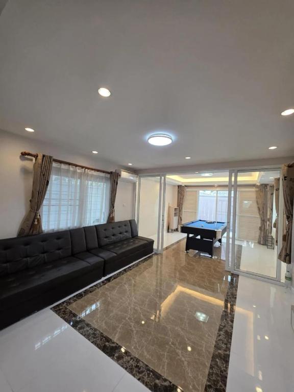 a living room with a couch and a pool table at Sugar Beach Villa Bangsaen in Ban Bang Saen (1)