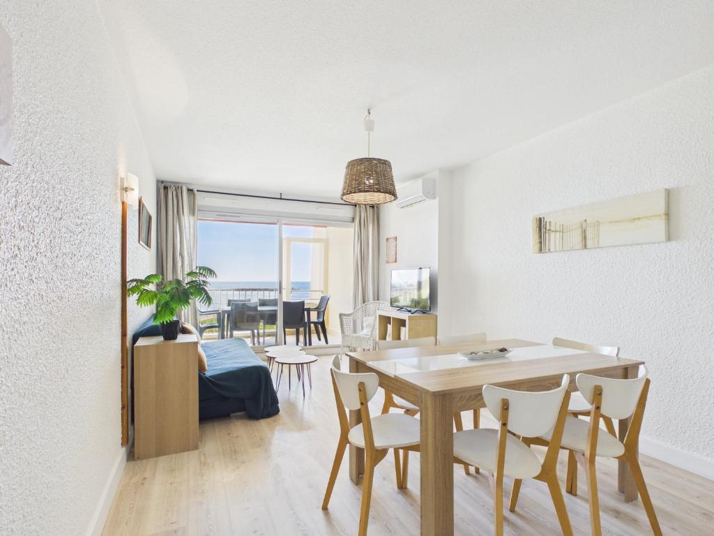 a dining room and living room with a table and chairs at Résidence de Tourisme l'Albatros in Palavas-les-Flots