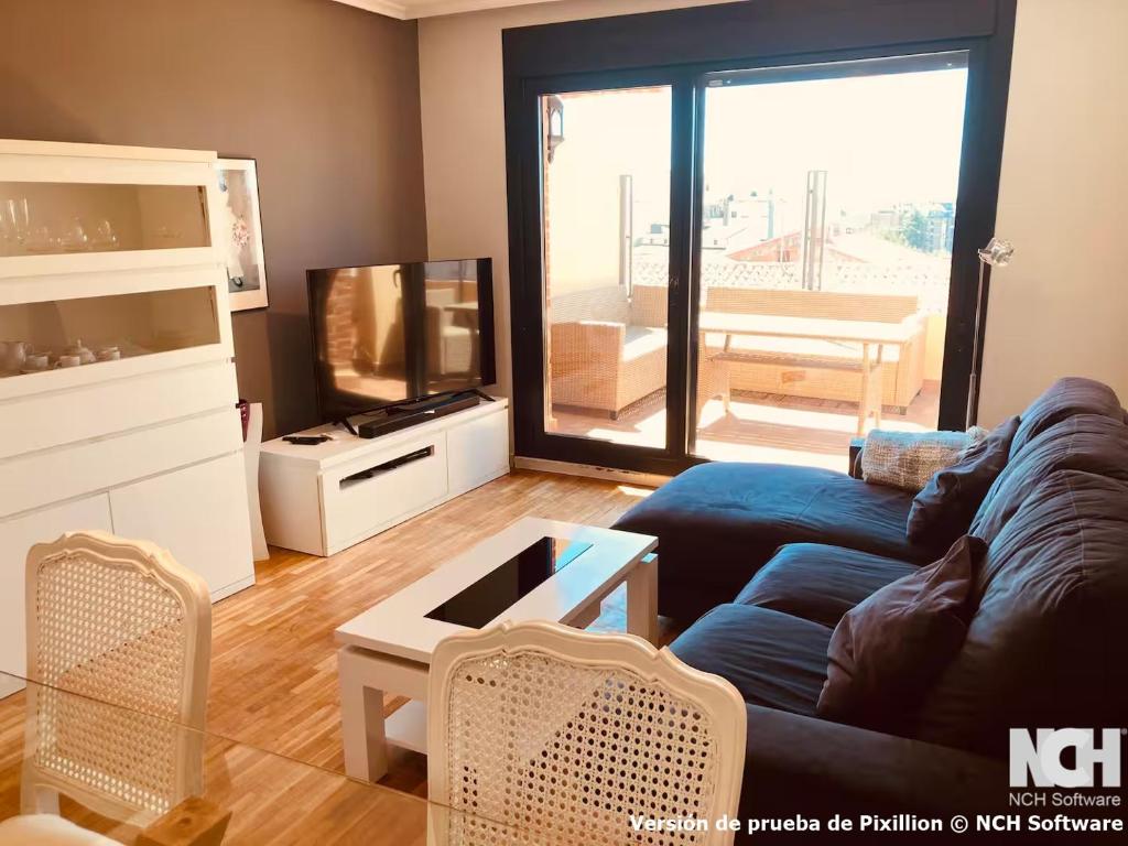 a living room with a blue couch and a television at Angel de la Guarda 18 in Soria