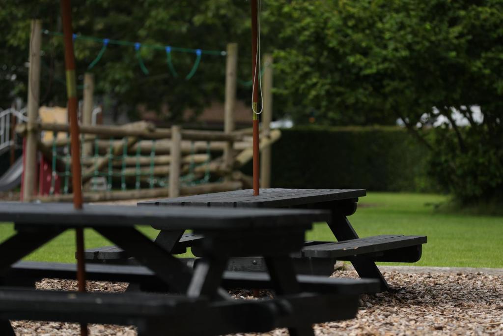 a picnic table in a park with a playground at Camping Pod's in Hanworth