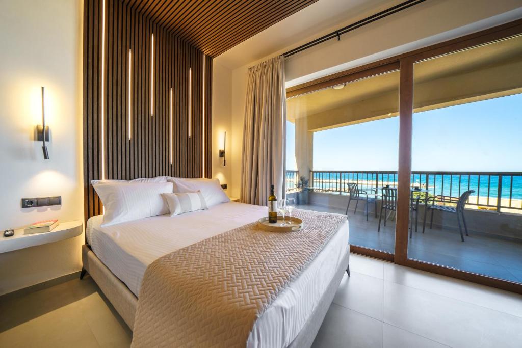 a bedroom with a bed with a view of the ocean at Solmare beachfront apartments in Panormos Rethymno
