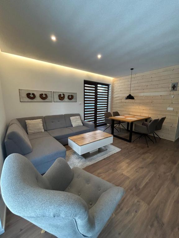 a living room with a couch and a table at Apartmán ESKIMO in Bystrá