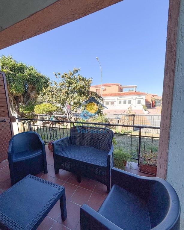 a patio with two chairs and a bench and a table at Sardegna 20 in San Teodoro