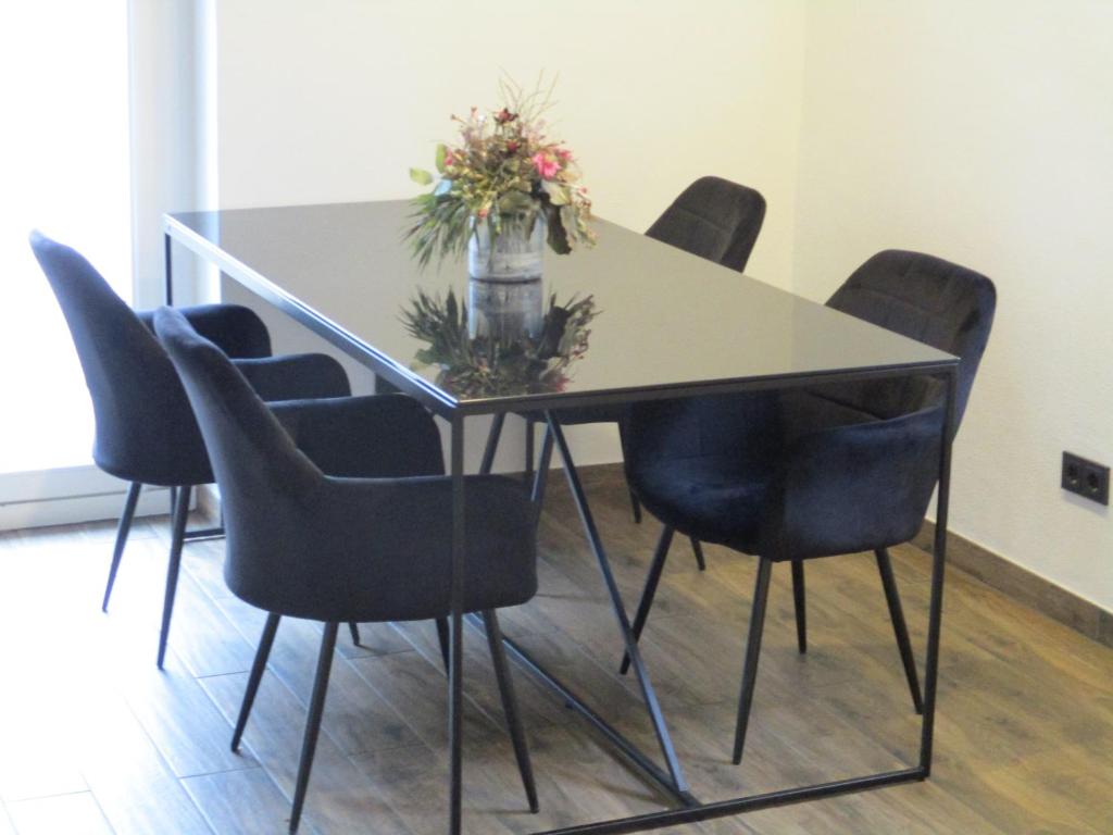 a table with chairs and a vase of flowers on it at Parsberger Ferienhaus 23 a in Parsberg